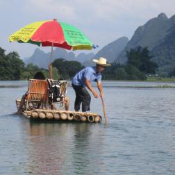 Steering the bamboo raft along the Yulong River in Yangshuo, China