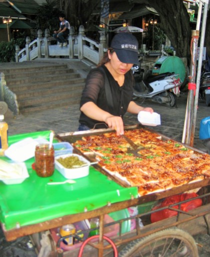 Woman selling mapo tofu, a popular Chinese dish consisting of a popular Chinese dish of tofu in a spicy chili sauce