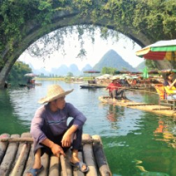 Our guide steering the bamboo raft along the Yulong River in Yangshuo China