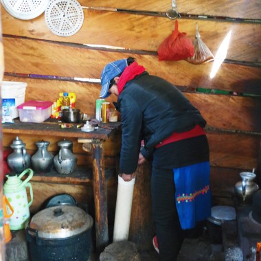 A Tibetan woman in Yubeng making Yak butter tea